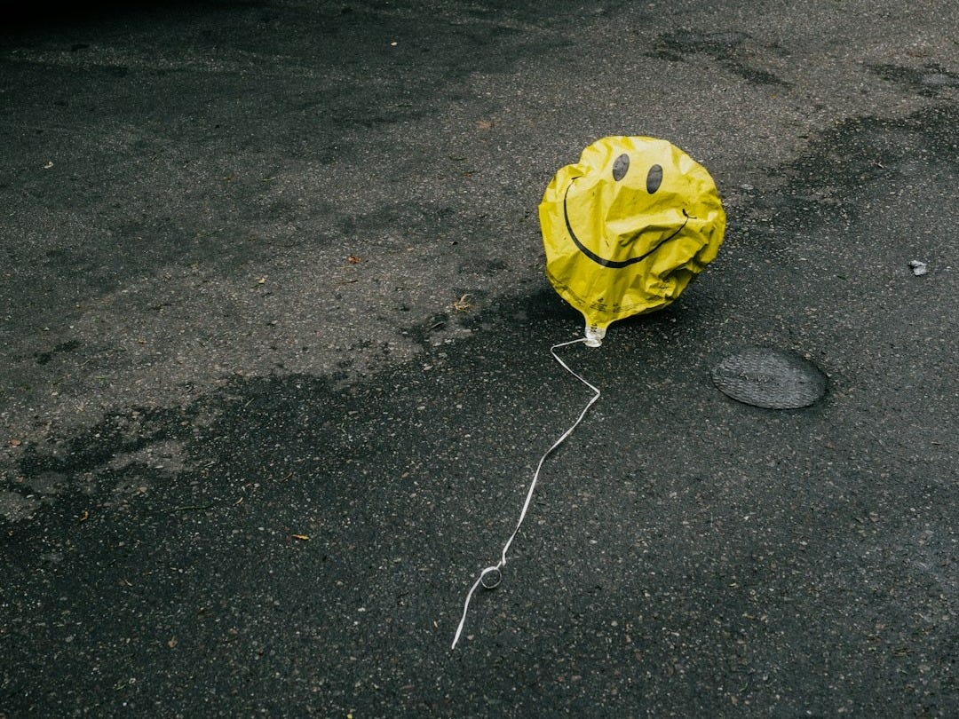 smiling emoji balloon beside black car during daytime smiling emoji balloon beside black car during daytime