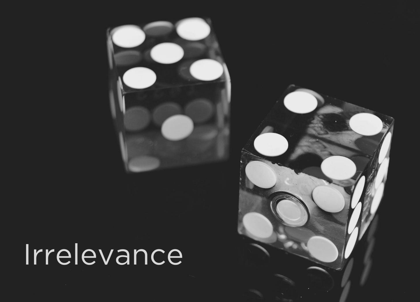 Black and white picture of two dice on a black surface. Text reads Irrelevance
