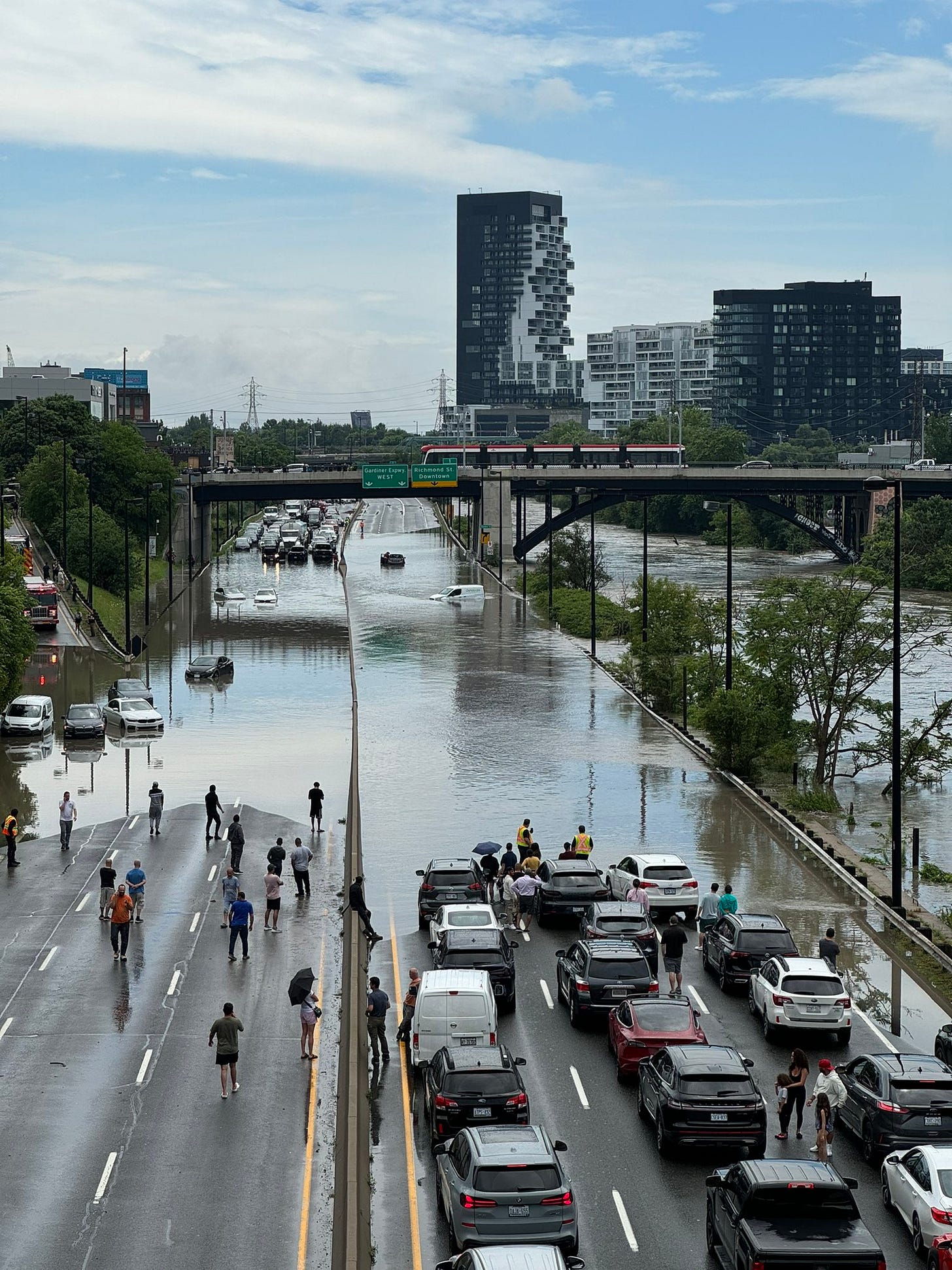 Flooded highway in Toronto with submerged vehicles and rising water levels, illustrating the impact of extreme rainfall and the need for climate-resilient infrastructure. Flooded highway in Toronto with submerged vehicles and rising water levels, illustrating the impact of extreme rainfall and the need for climate-resilient infrastructure.