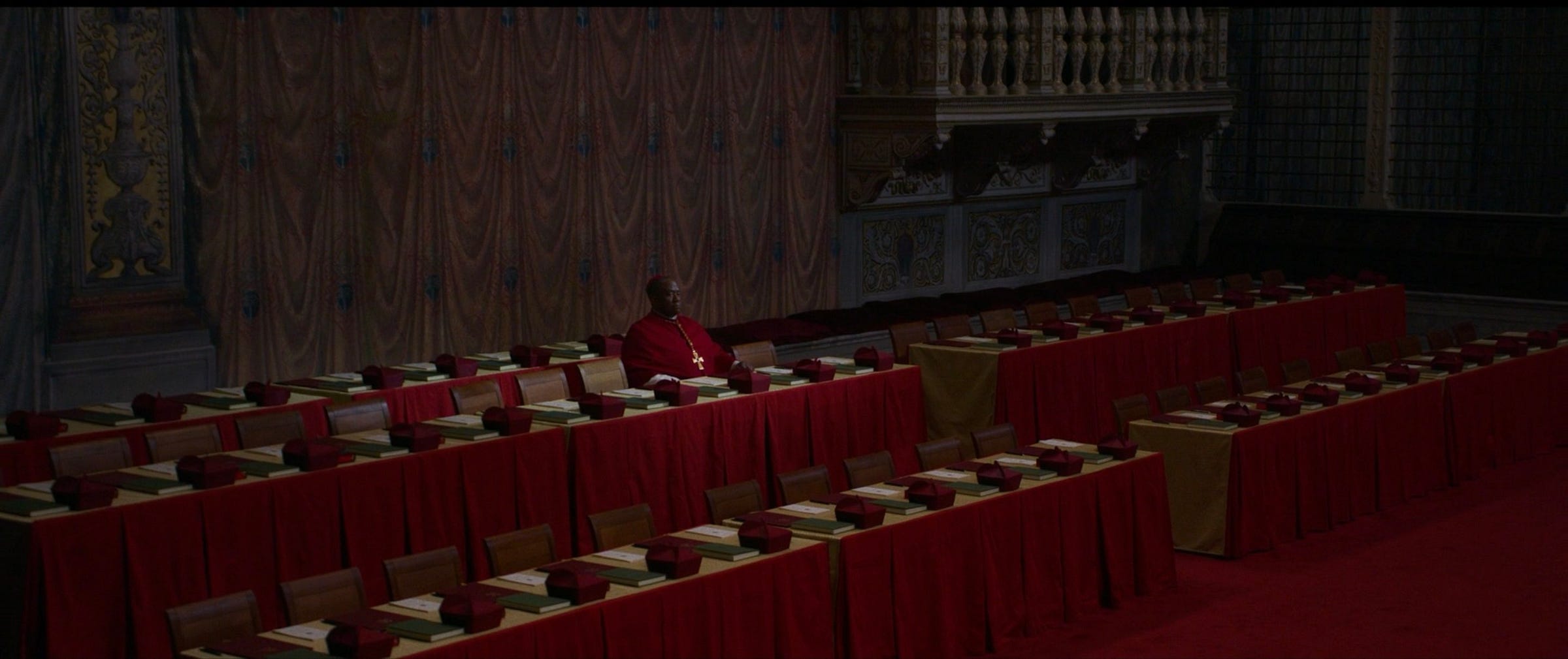 Screenshot from "Conclave." Cardinal Adeyemi sits alone after losing his supporters.