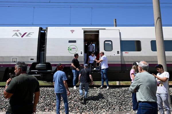 Rail passengers are helped off a stalled train.