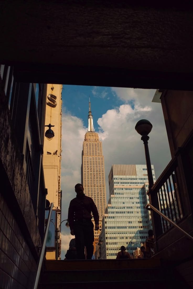 This may contain: a man walking up some stairs in front of a tall building