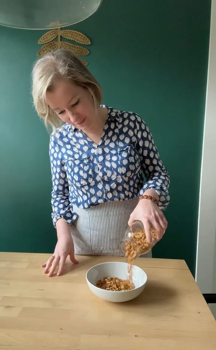 Woman making homemade cereal and slicing a banana into it.