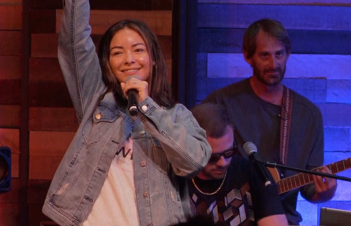 Women leading church worship music with her right-arm upraised Women leading church worship music with her right-arm upraised