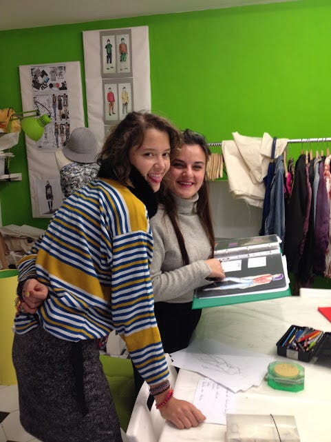 1) Lila Sky de espaldas, frente a una máquina de cose y bajo una lámpara, mientras confecciona. 2) Lila Sky y su maestra de diseño de modas en el taller de la Accademia D'Arte AD'A