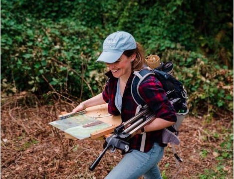 A person carrying a painting on a wood plank

Description automatically generated
