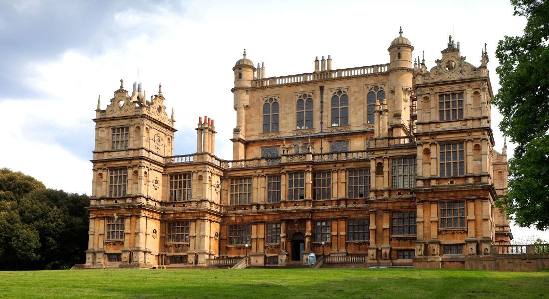 A large brown Elizabethan building, Wollaton Hall, with a green lawn in front of it