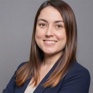 Mulher branca jovem de cabelo escuro, sorrindo em direção à câmera de braços cruzados. Mulher branca jovem de cabelo escuro, sorrindo em direção à câmera de braços cruzados.
