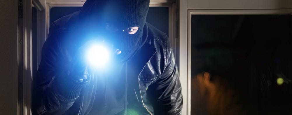 A masked burglar shining a flashlight in the viewer's eyes A masked burglar shining a flashlight in the viewer's eyes