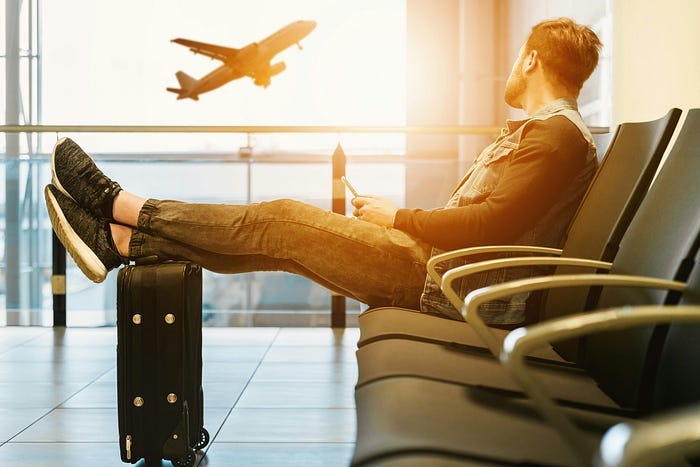 A guy sits in an airport, waiting for his plane. A guy sits in an airport, waiting for his plane.