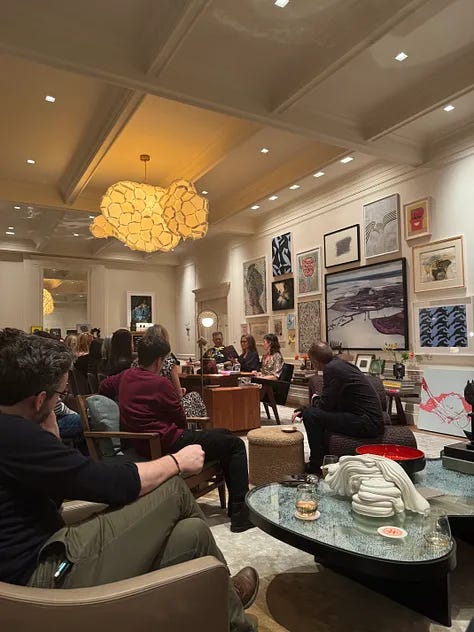 A living room filled with people and three people presenting