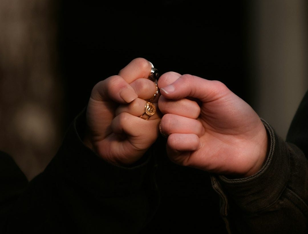 person holding gold ring in dark room