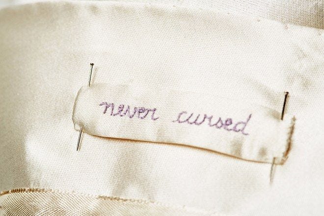 This may contain: there is a label on the back of a shirt that says, never covered up