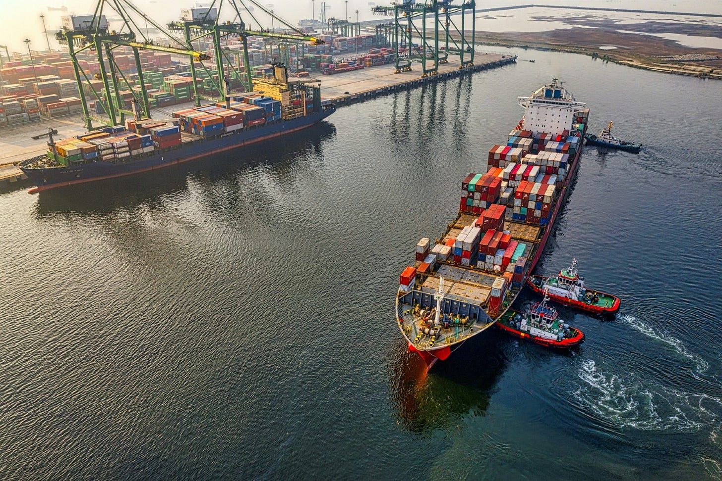 huge containership being docked by three tugboats huge containership being docked by three tugboats