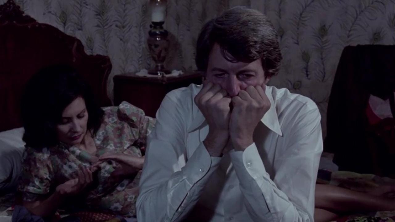 Castle of Purity | Still features a man in anguish while a woman is in bed behind him.