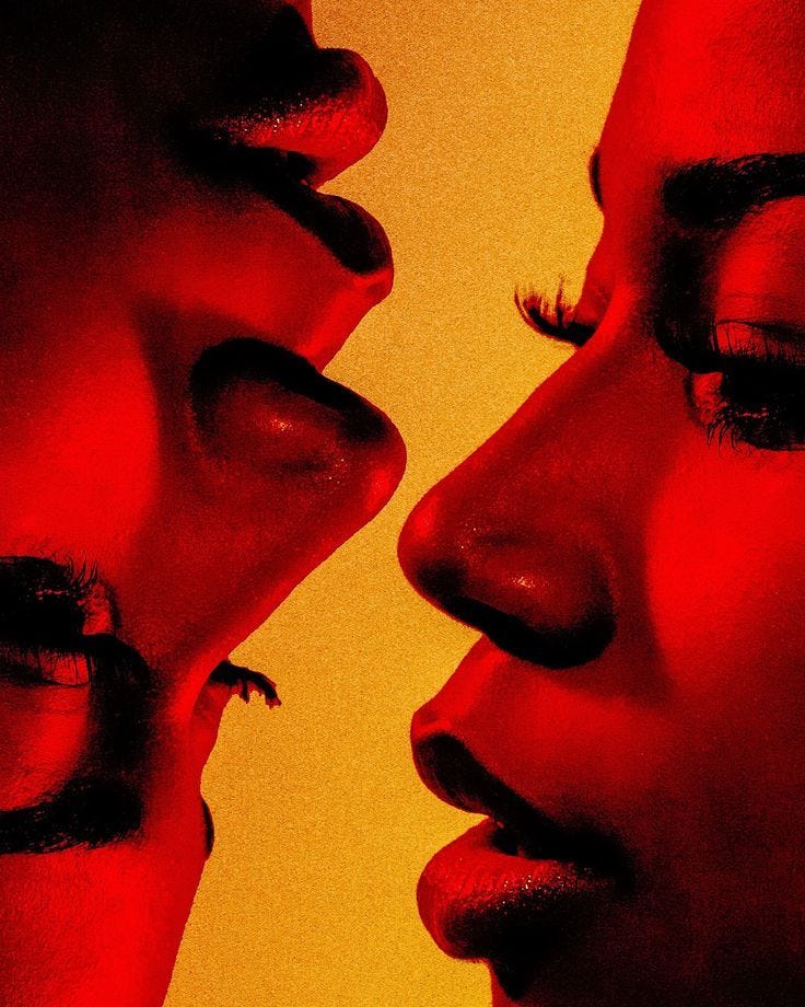 Close-up portrait of two women facing each other under dramatic red lighting, high-contrast beauty photography with intense shadows and bold makeup.