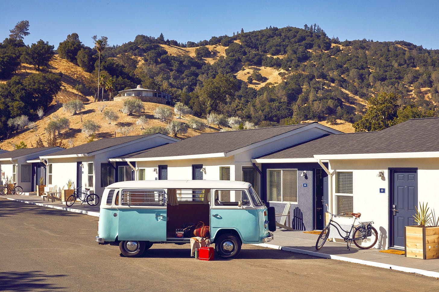 a blue VW van parked in front of a motel