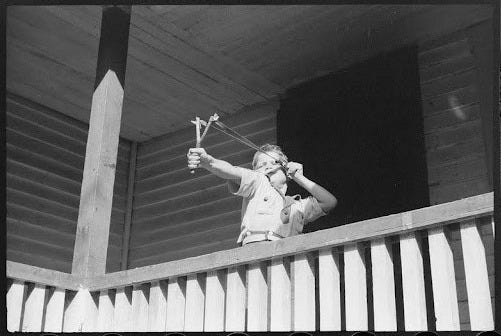 Young boy throwing a slingshot