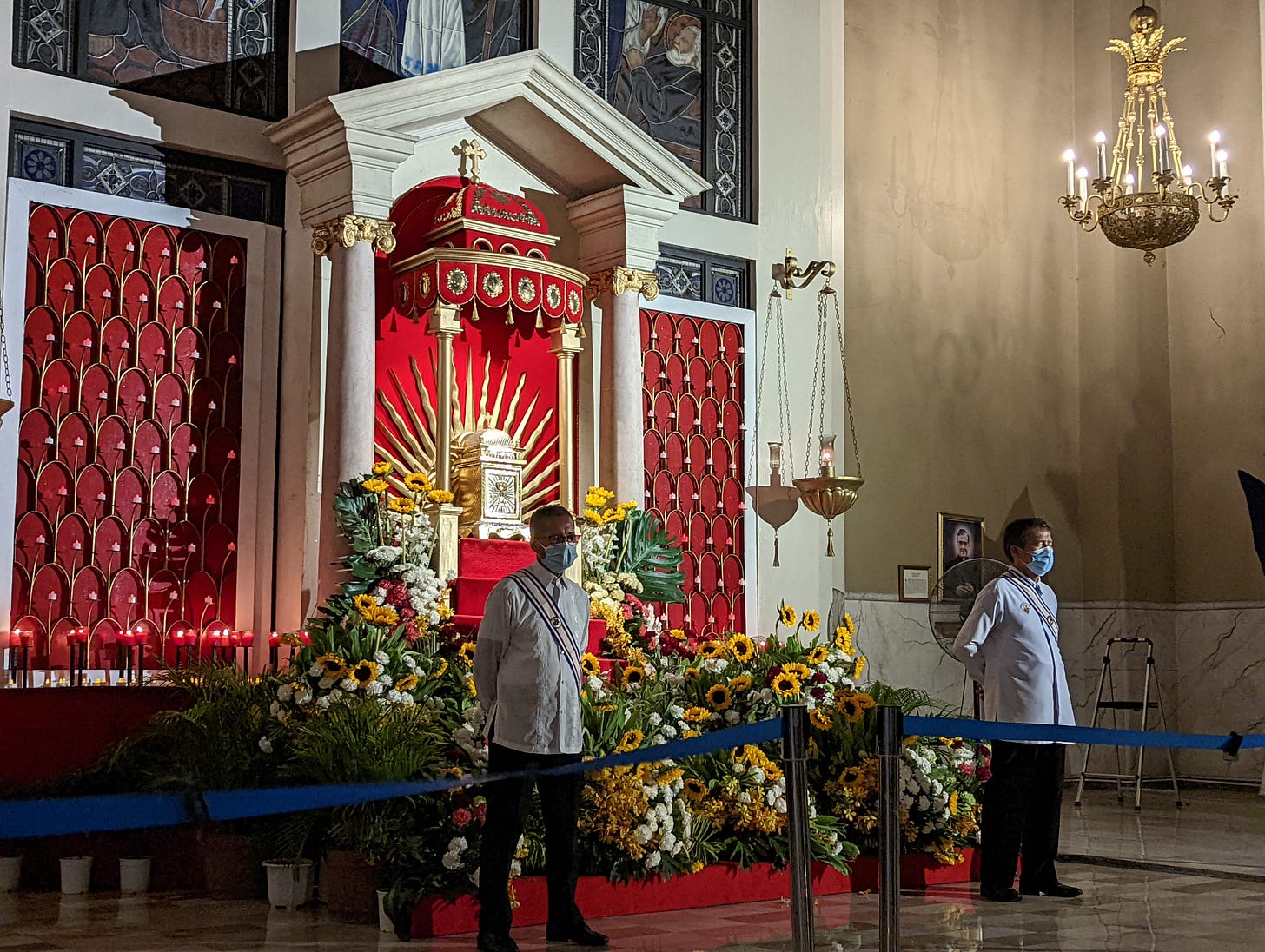 The altar of repose of the Cathedral of Cubao showing its red and gold design along with two people guarding it