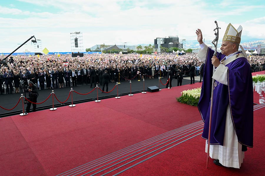 Pope Leo XIV blesses crowd in Lebanon purple robes red stage Pope Leo XIV blesses crowd in Lebanon purple robes red stage