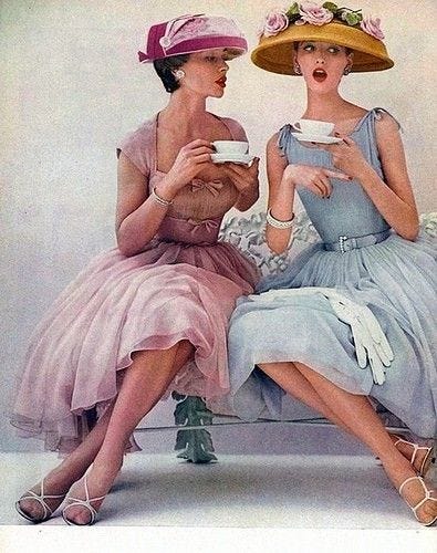 two women dressed for a genteel tea party, one saying something that shocks the other