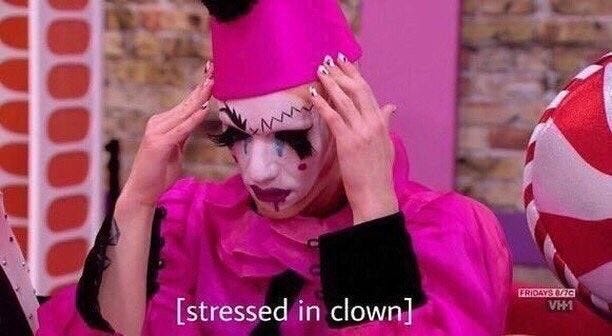 This may contain: a woman with clown makeup is holding her head in front of her face and looking at the camera