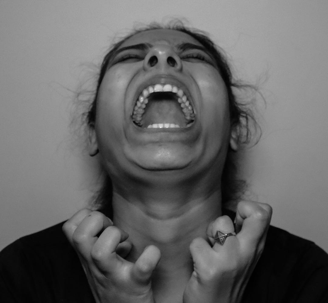 a woman with her mouth open and hands in front of her face a woman with her mouth open and hands in front of her face