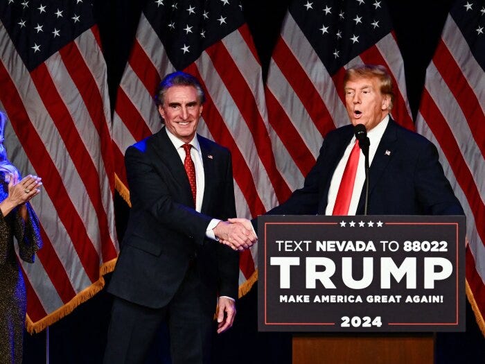 Kathryn Burgum aplauds as her husband Republican Governor of North Dakota Doug Burgum shakes hands with former US President and 2024 presidential hopeful Donald Trump during a Caucus Night watch party in Las Vegas, Nevada, on February 8.