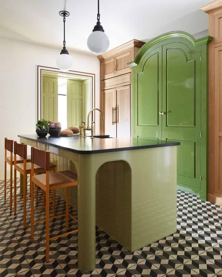 Green kitchen with small-tiled black and white floor.