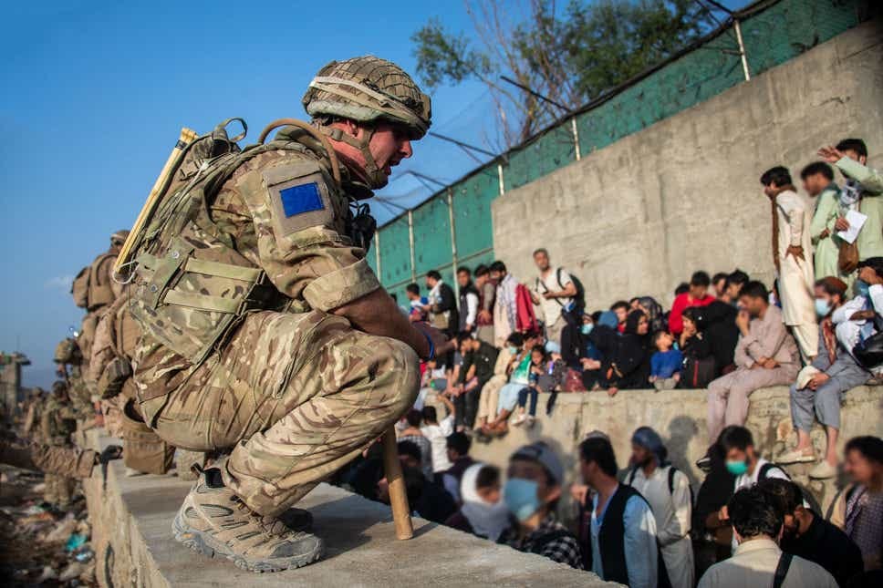 <p>Afghans queue for an evacuation flight out of Kabul (LPhot Ben Shread/MoD/PA)</p>