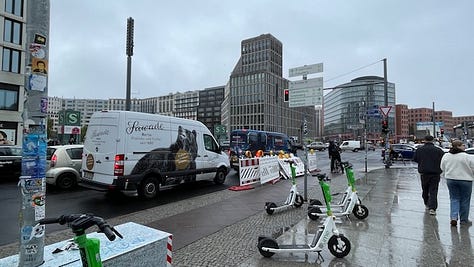 Two images of the busy intersection of Potsdamer Platz in November 2024. One image of the remaining slabs of the Berlin Wall at Potsdamer Platz, November 2024