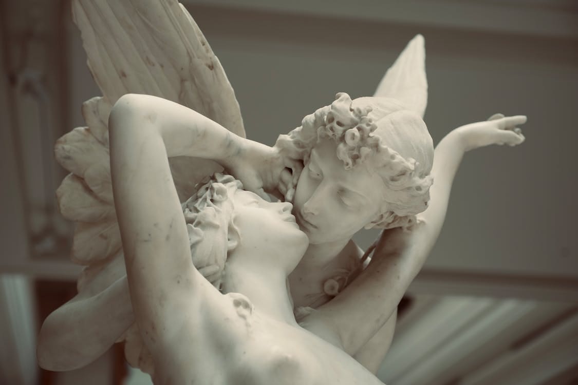 Free Elegant marble sculpture depicting the tender embrace of Cupid and Psyche. Stock Photo
