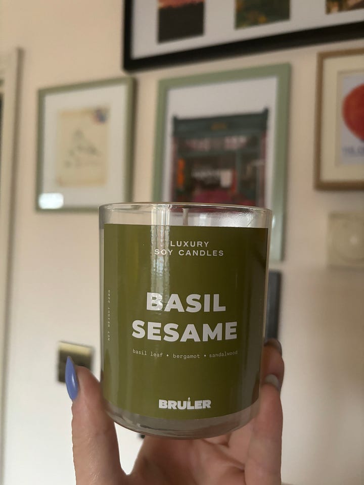 1. package with bold text reading BRULER BRULER BRULER BRULER BRULER. 2. big glass candle pot with green label reading BASIL SESAME in bold font.