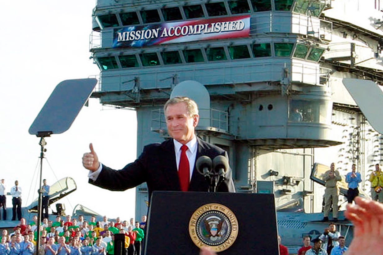 President George W. Bush declares the end of major combat in Iraq under a “Mission Accomplished” banner aboard the aircraft carrier Abraham Lincoln off the California coast on May 1, 2003.
