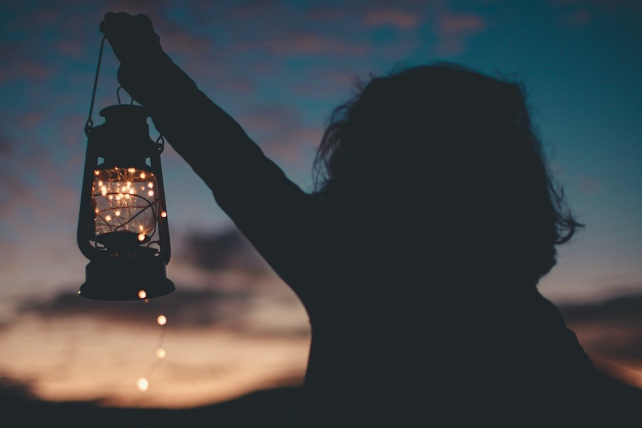 Person holding a lantern at sunset Person holding a lantern at sunset