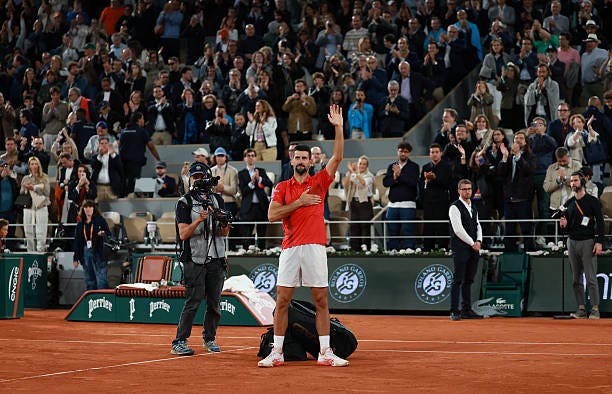 Novak Djokovic of Serbia applauds the crowd after placing his bag on the court after his defeat to Jannik Sinner of Italy in the Men's Singles Semi...