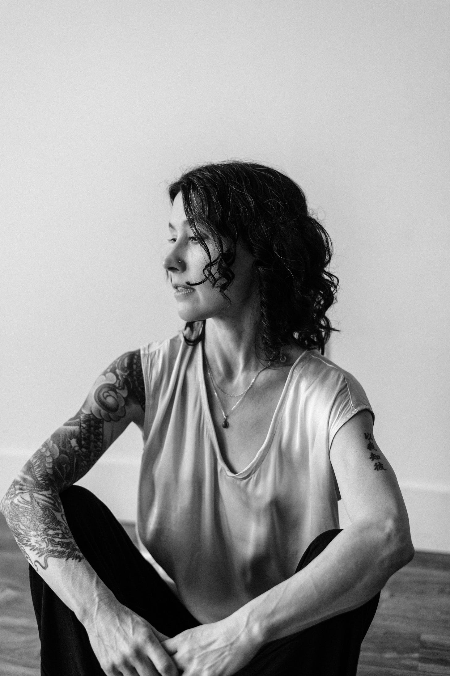 Image of author seated on the floor looking down in black and white