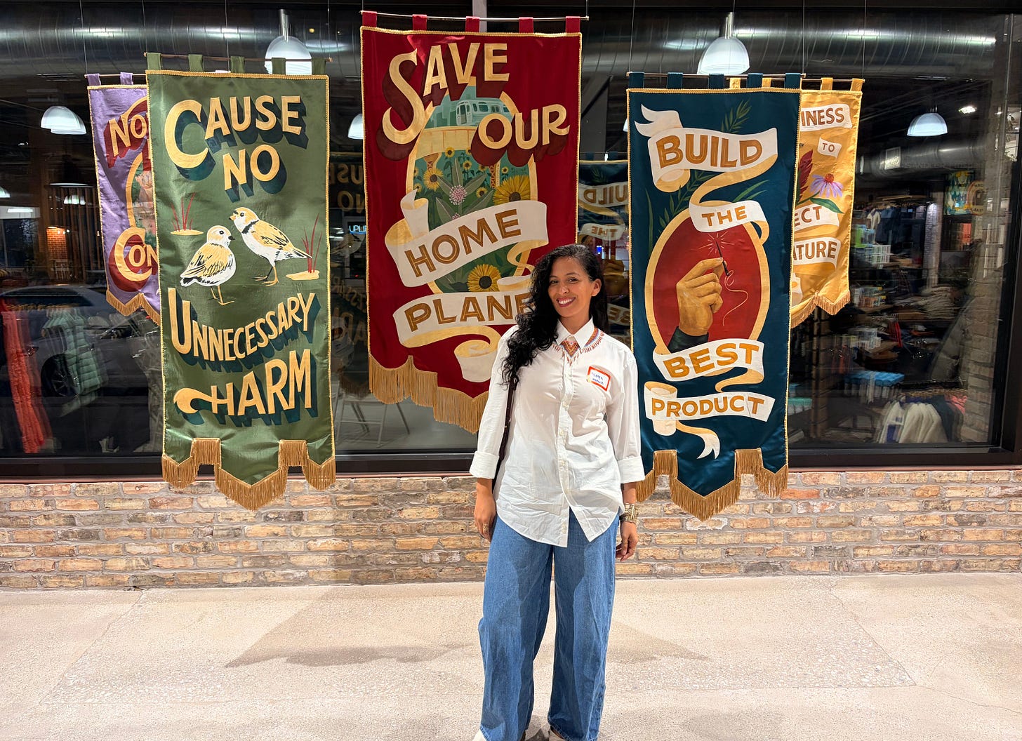 Mireya in front of "Save our home planet sign" at Patagonia store Mireya in front of "Save our home planet sign" at Patagonia store
