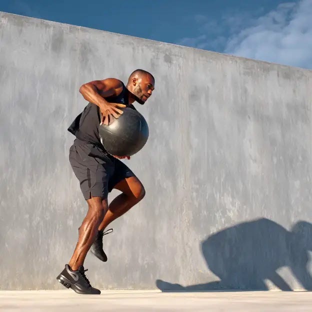 Fit athletic man doing medicine ball throws against the wall for explosive core training. Fit athletic man doing medicine ball throws against the wall for explosive core training.