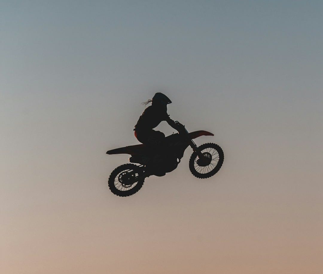 man riding motorcycle on brown grass field during daytime