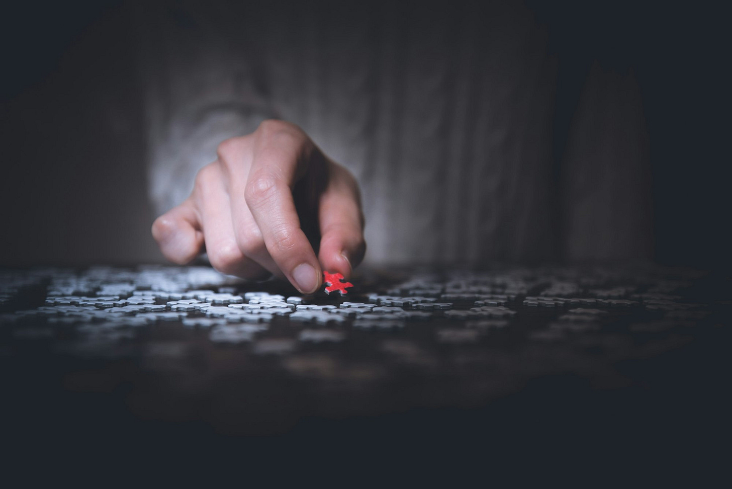 A hand placing the final piece into a jigsaw puzzle, symbolizing the transition from tech to management roles A hand placing the final piece into a jigsaw puzzle, symbolizing the transition from tech to management roles