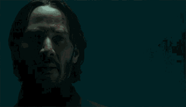 a man with a beard stands in front of a sign that says " yeah "