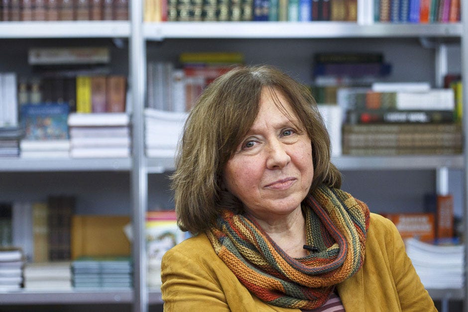 Writer Svetlana Alexievich in a yellow top in front of a bookshelf Writer Svetlana Alexievich in a yellow top in front of a bookshelf