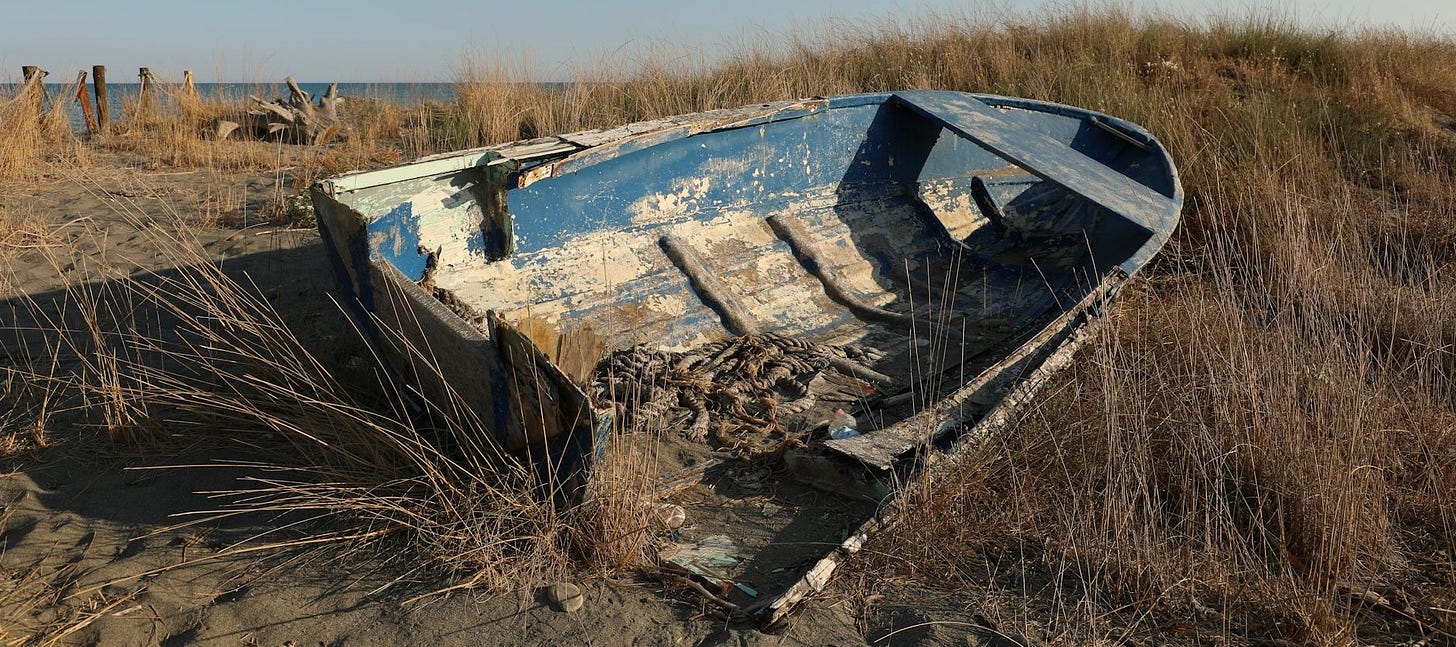 A decaying boat on the shore of a beach. A decaying boat on the shore of a beach.