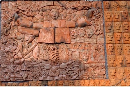 A sculpture of a person with a chain on a wall