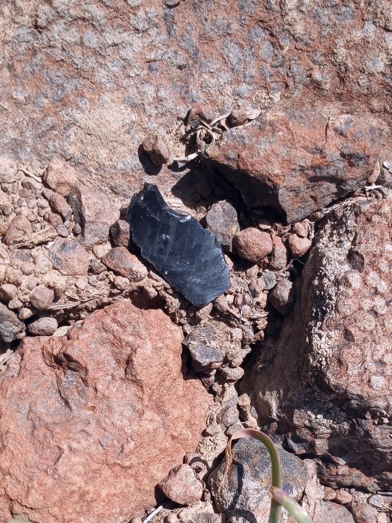 Photo 11: Knapped obsidian shards, and some nearly complete arrowheads, are a regular and repeated occurrence in these rock flow areas Photo 11: Knapped obsidian shards, and some nearly complete arrowheads, are a regular and repeated occurrence in these rock flow areas