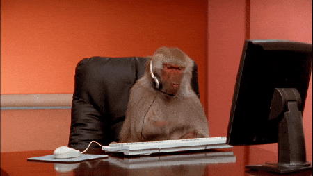 This may contain: a monkey sitting at a desk with headphones in front of it's face