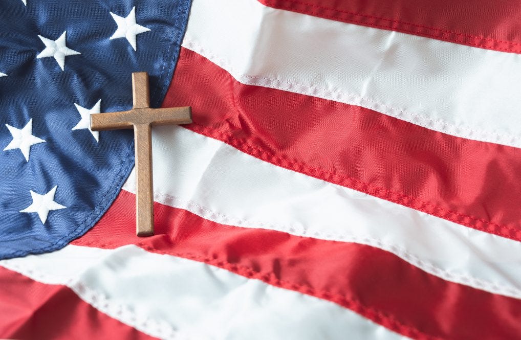 A wooden cross sits on top of an American flag. A wooden cross sits on top of an American flag.