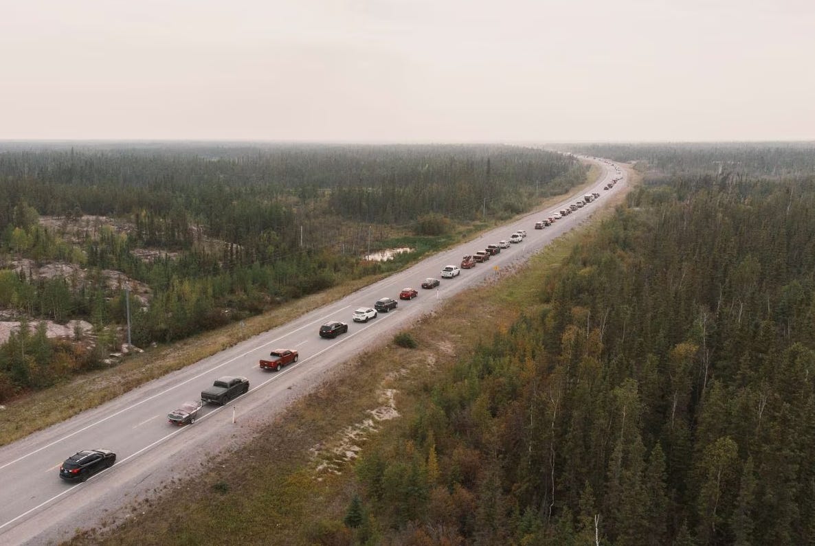 Photo of cars lined up into the distance fleeing the Yellowknife fire in Canada, sky thck with smoke haze. Photo of cars lined up into the distance fleeing the Yellowknife fire in Canada, sky thck with smoke haze.