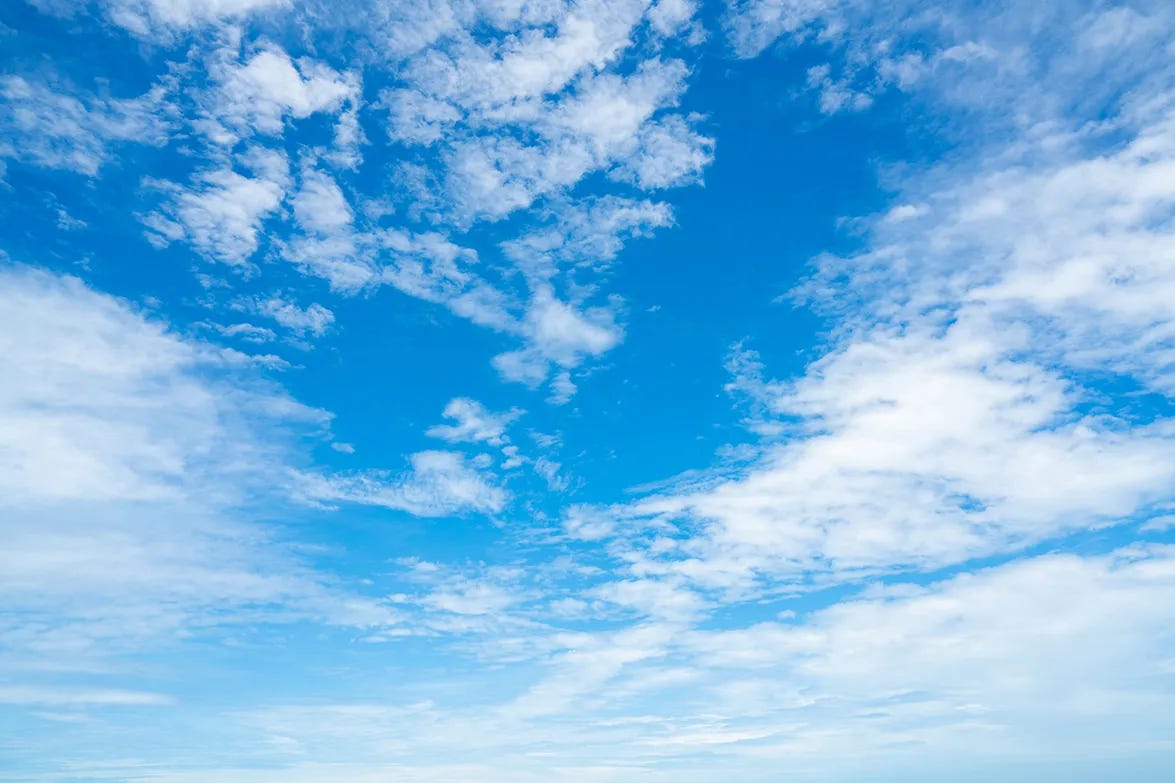 View of a bright blue sky with a few white clouds View of a bright blue sky with a few white clouds